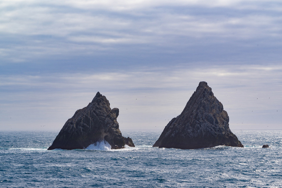 Rugged sea stacks along a North Atlantic coastline under moody skies