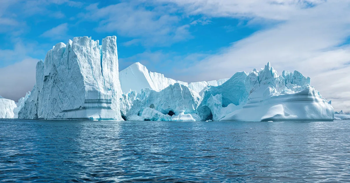 Steep iceberg cliffs under a clear blue sky